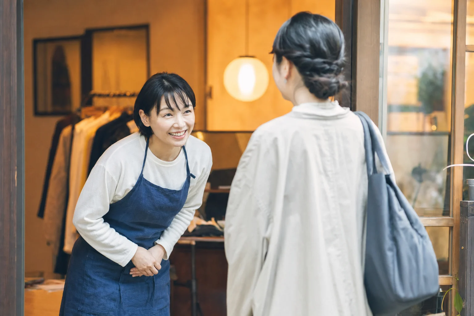 会計を終えたお客様を笑顔で見送る店舗スタッフ