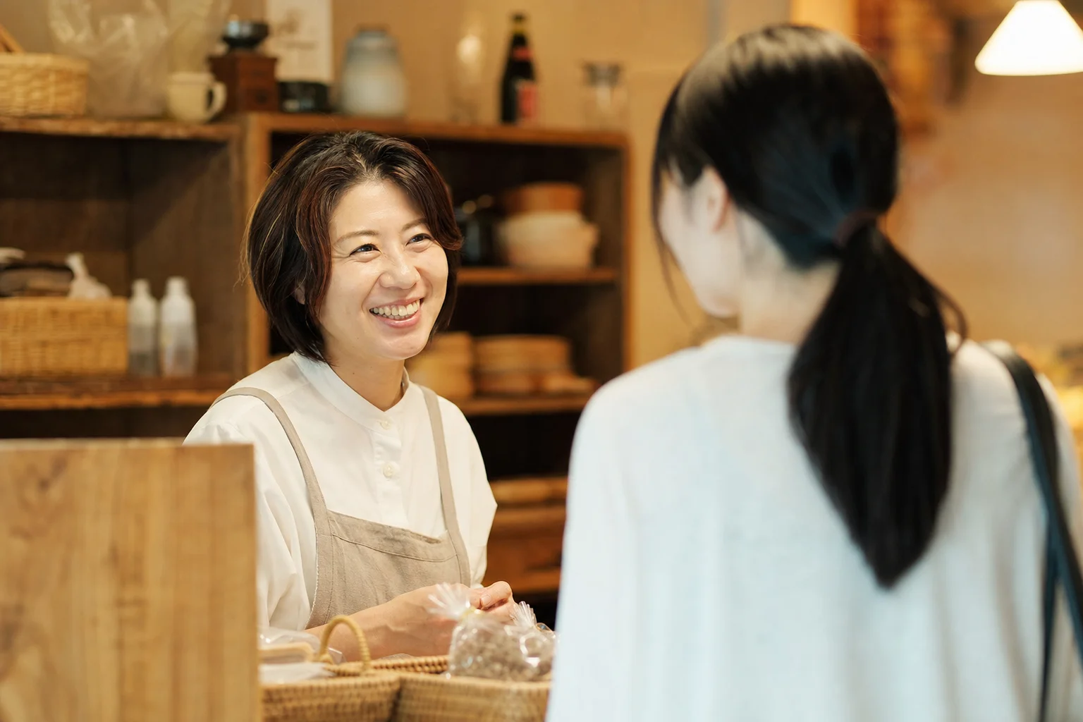 店内でスタッフが笑顔の常連客と会話する温かな接客の様子